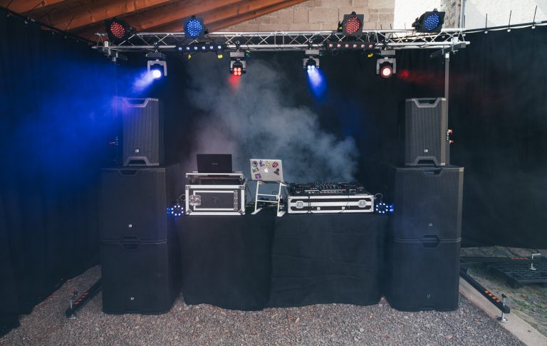 Veranstaltungstechnik DJ-Ausrüstung mit Lautsprechern, Mixer und Nebel in einem Raum.